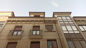 坎巴多斯Aronda Cambados apartamento céntrico的一座高高的砖砌建筑,设有窗户和阳台