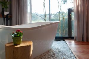 乌鲁比西Green Barn Hotel & Bistro的带浴缸和木盆的浴室