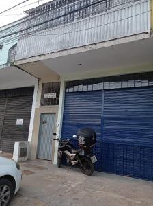 巴西利亚APTO COM VARANDA - 5KM DO AEROPORTO BSB - Nucleo Bandeirante的停放在车库前的摩托车