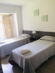 卢汉德库约Hermosa casa con Jacuzzi y sauna en Chacras de Coria的酒店客房设有两张床和窗户。