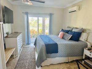 Moss TownBeautiful Island Villa - Beach Access on Private 2 Acres的一间卧室配有一张带蓝色和粉红色枕头的床