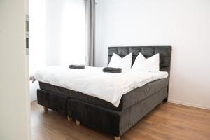蒂米什瓦拉Alternativ 2 Residence Central的一张带黑色床头板和白色枕头的床