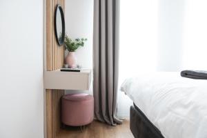 蒂米什瓦拉Alternativ 2 Residence Central的一间卧室配有床、镜子和粉红色凳子