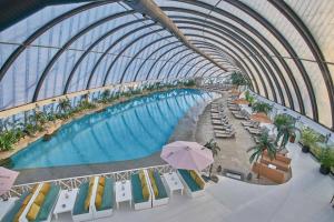 阿斯塔纳Apart Astana, Комплекс Alpamys возле ЭКСПО的享有带椅子和遮阳伞的游泳池的上方景致