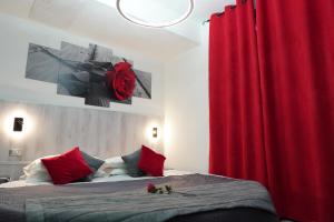 加尔达湖滨卡纳瑞诺酒店的一间卧室配有一张带红色窗帘的床