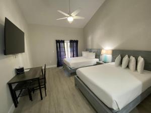 基拉戈Amoray Dive Resort的一间卧室配有两张床、一张桌子和一台电视。