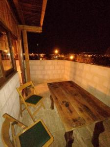 阿瓦诺斯Begam Butik Otel的夜间阳台上的木桌和椅子
