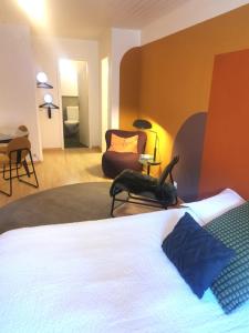 拉诺伊韦维尔Studios des Arcades的一间卧室,卧室内配有一张床和一把椅子