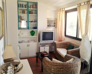 加埃塔Gaeta Villino Isabella的客厅配有两把椅子和电视