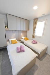 德拉格O'LIVE PREMIUM Mobile Home的客房内的两张床和粉红色枕头