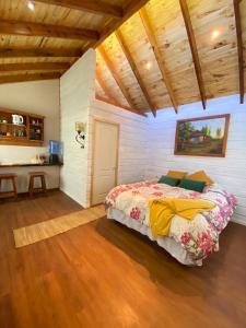 MaipoLoft Cabaña El Recuerdo的一间带一张床的卧室,位于带木制天花板的房间内