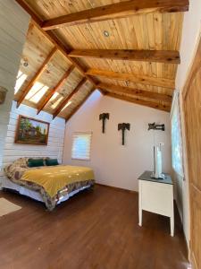 MaipoLoft Cabaña El Recuerdo的一间卧室设有一张床和木制天花板