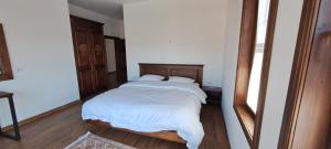 培拉特Pupa Winery Serene Stay的一间卧室配有一张带白色床单和镜子的床