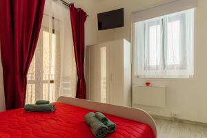 卡塔尼亚Casta Diva Holiday Rooms的一间卧室配有红色的床和2条毛巾