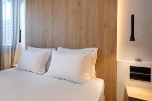 雅典A&N Athens Luxury Apartments - Ermou的一间卧室配有带白色床单和枕头的床。