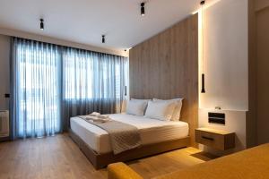 雅典A&N Athens Luxury Apartments - Ermou的一间卧室设有一张床和一个大窗户