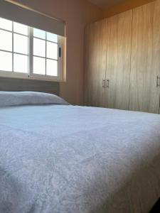 努尔德Cozy Apartment a 2 minutes to the Marriott的卧室配有一张白色大床和木制橱柜。