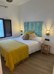 塔韦尔纳斯Casa La Zurita的一间卧室设有两张带蓝色床头板的床和一张桌子。