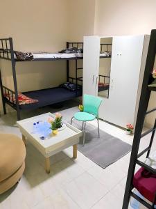 阿布扎比MBZ - Nice Bed Space "MEN"的客房设有两张双层床和一张桌子及椅子。