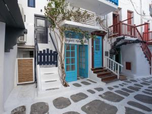 米克诺斯城Silvernoses Little Venice, Mykonos Town的白色建筑的蓝色门,设有楼梯