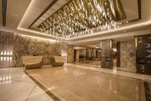 钦奈Radisson Blu Hotel GRT, Chennai International Airport的大堂设有带椅子和灯的酒吧