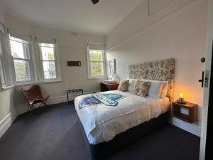 悉尼The Resch House的一间卧室配有一张床、一把椅子和窗户。