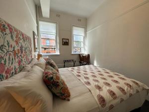 悉尼The Resch House的一间卧室设有一张大床和两个窗户。