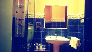 LagarteraEl Huésped del Sevillano AR的蓝色瓷砖浴室设有水槽和镜子