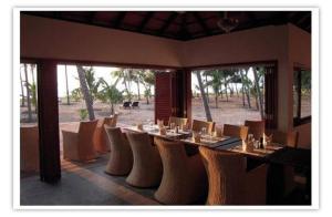 Nīleshwar卡南海滩度假村的享有美景的带桌椅的用餐室