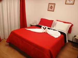 MeloGoverno's House的一间卧室配有红色的床和毛巾