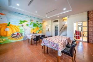礁溪田念民宿的一间设有两张桌子和南瓜壁画的用餐室