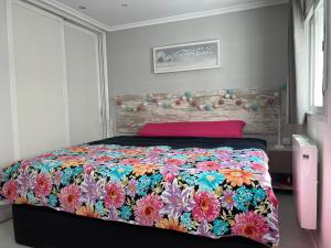 Carabanchel AltoLuminoso apartamento con precioso y amplio patio的一间卧室配有一张带五颜六色被子的床