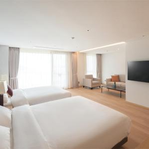 SinanC-One Resort Jaeundo的酒店客房设有两张床和一台平面电视。