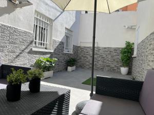 Carabanchel AltoLuminoso apartamento con precioso y amplio patio的庭院设有两张桌子和一把伞