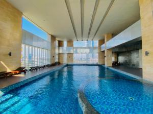雅加达Habitare Apart Hotel Rasuna Jakarta Powered by Archipelago的一座大型游泳池,位于一座带大窗户的建筑内