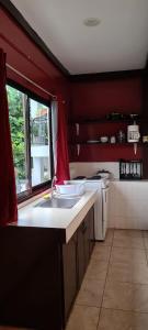 科罗尔Paradise Comfort的一个带水槽和红色墙壁的厨房