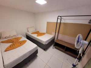 圣保罗Self Hostel的小型客房配有2张床和风扇。