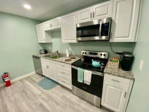 盖恩斯维尔Serene renovated oasis near downtown area的厨房配有白色橱柜和炉灶烤箱。