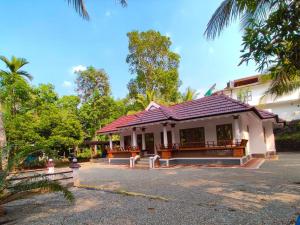 PalaKizhakkethottam Homestays-River View Villa的街道上一座红色屋顶的建筑