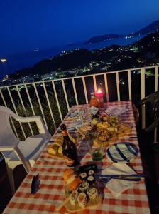 莱里奇LA CASTELLANA Una Finestra sul Mare- Air Conditioned的阳台上的桌子上摆放着食物和一瓶葡萄酒