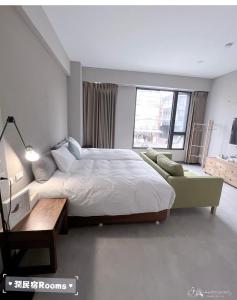 花莲市润民宿的一间卧室配有一张大床、一张桌子和一张沙发