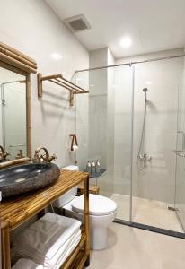 胡志明市Song Anh Indochina Studios Nguyen Thai Binh的一间带玻璃淋浴和卫生间的浴室