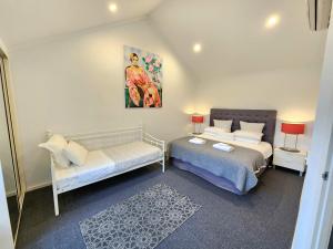 阿德莱德Spacious 4 BR and 2 Bathrooms City Apartment的一间卧室配有两张床和一张沙发。