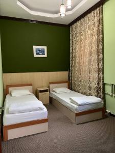 奎兹洛达Гостиница Селена的绿墙客房内的两张床
