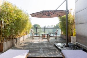 杭州杭州西溪南庐君亭酒店的木甲板配有桌子和遮阳伞