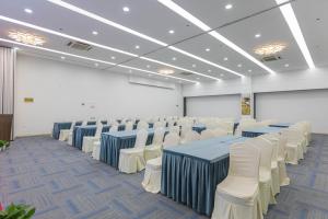 杭州杭州西溪南庐君亭酒店的一间会议室,配有蓝色的桌子和白色的椅子