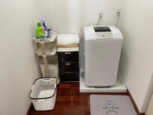 宫古岛一棟貸しの宿 民宿せいじん家的洗衣房的架子上设有洗衣机和烘干机