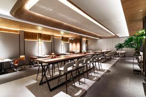 南京南京南站逸扉酒店的一间带长桌和椅子的用餐室