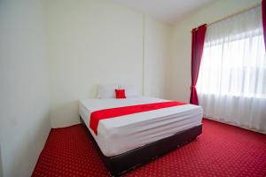 TingkeumRedDoorz Syariah near Rembele Airport Bener Meriah的卧室配有白色床和红地毯