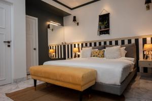 巴加Richmonde Ananta Elite Luxurious Villa & Apartments,Goa的卧室配有白色大床和长凳